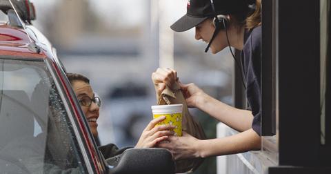 A fast-food employee gives a customer her order - stock photo