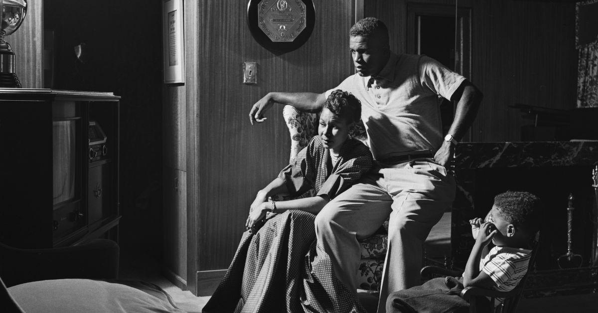 Rachel Robinson, Jackie Robinson, and Jackie Robinson Jr. watching TV at their home.
