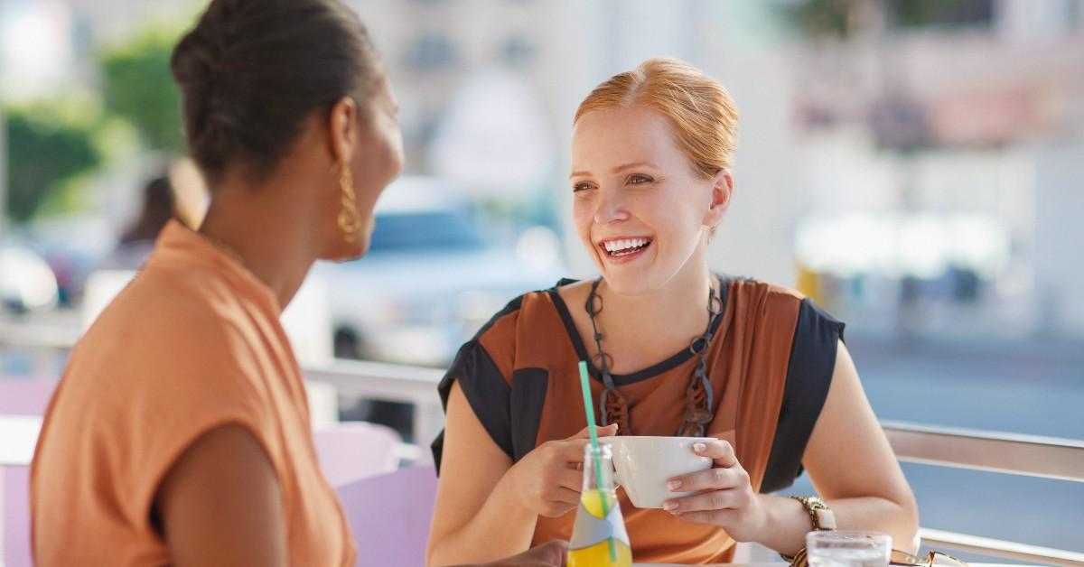 Two women laughing in a cafe. 