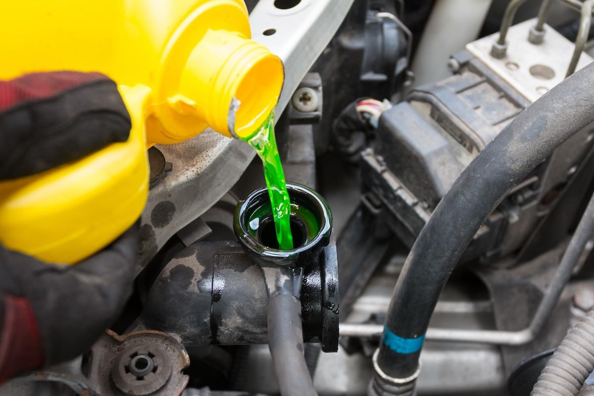 Green coolant being poured into a car