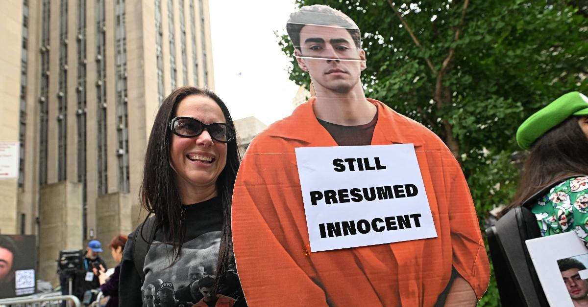 Luigi Mangione supporter holds up a cardboard cutout of the accused killer