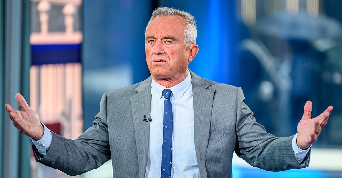 Robert F. Kennedy Jr. wearing blue tie and holding his hands up