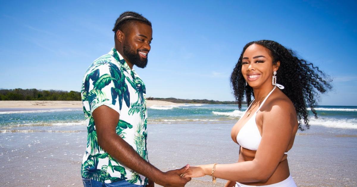 Alexis Nicole, Devon Wright hold hands on the beach and smile.