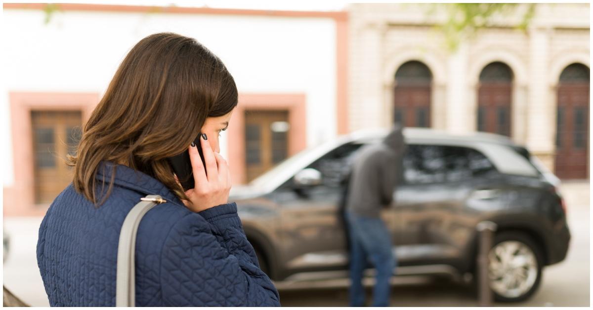 A woman calling the police on a car thief.