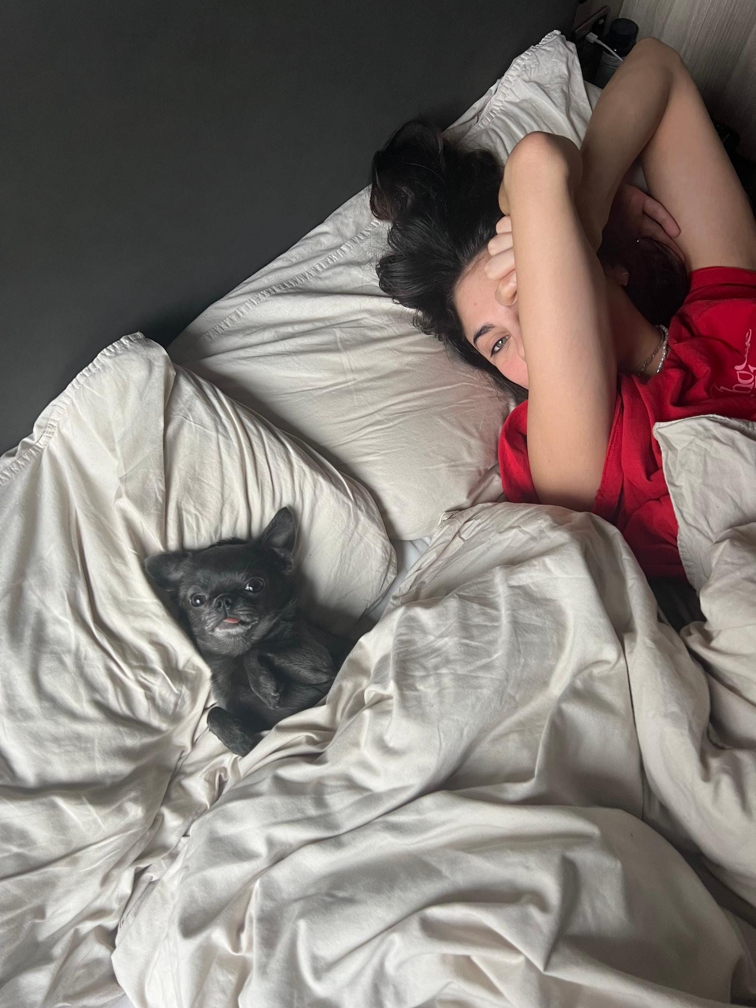 Kai Novak in bed with her dog