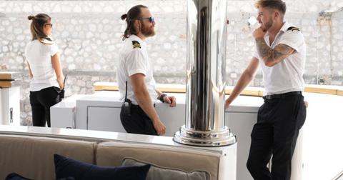 Gael Cameron stands in the background as Iain Maclean and Nathan Gallagher speak to each other on 'Below Deck Med'