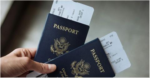A person holding two passports with aiplane boarding passes