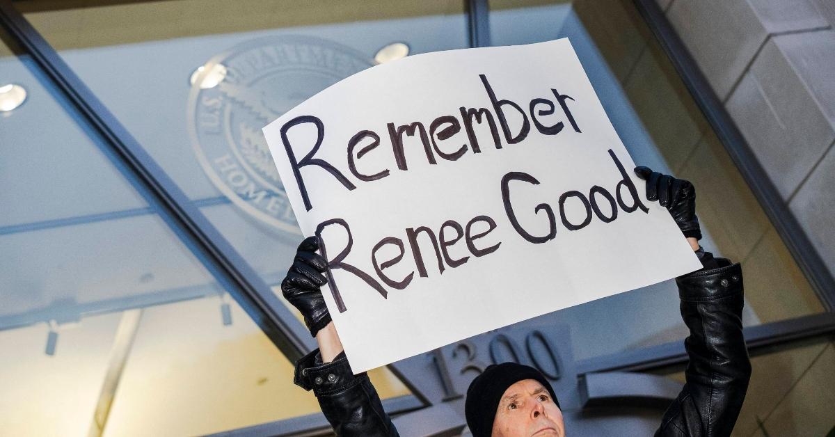 Protester holding up a sign that reads, "Remember Renee Good"