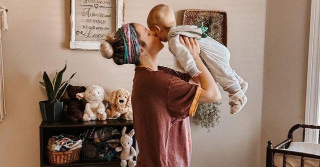 Jill Duggar kissing her youngest son, Frederick's cheek.