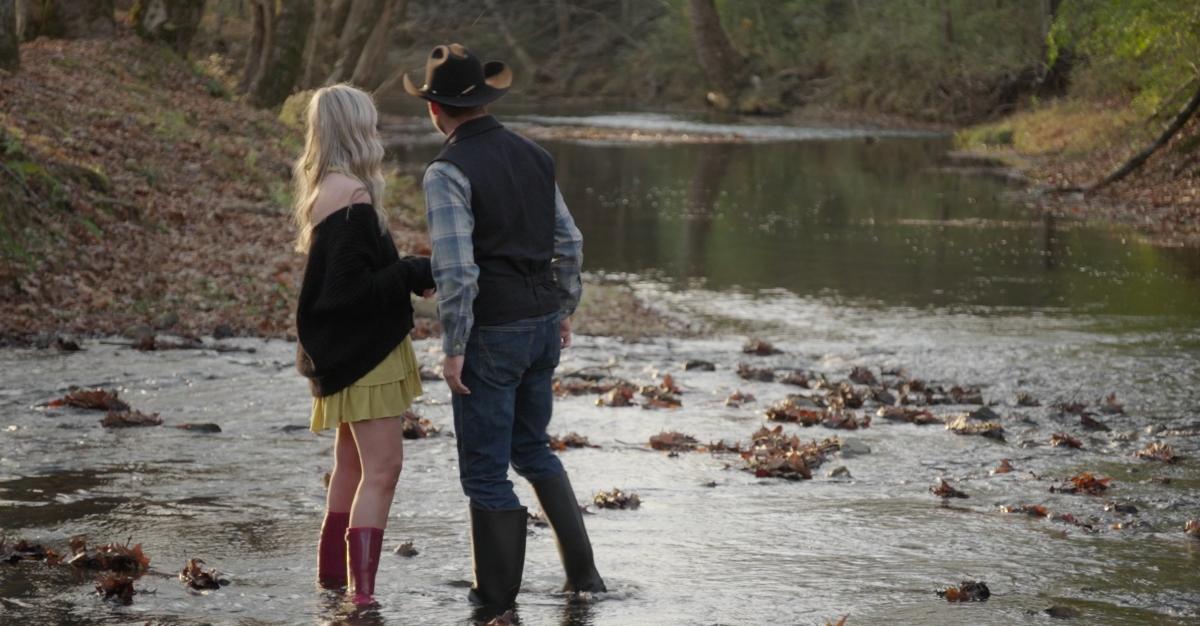 Hunter Grayson and Meghan Baker from ‘Farmer Wants a Wife’ stand in a creek during Meghan's hometown date