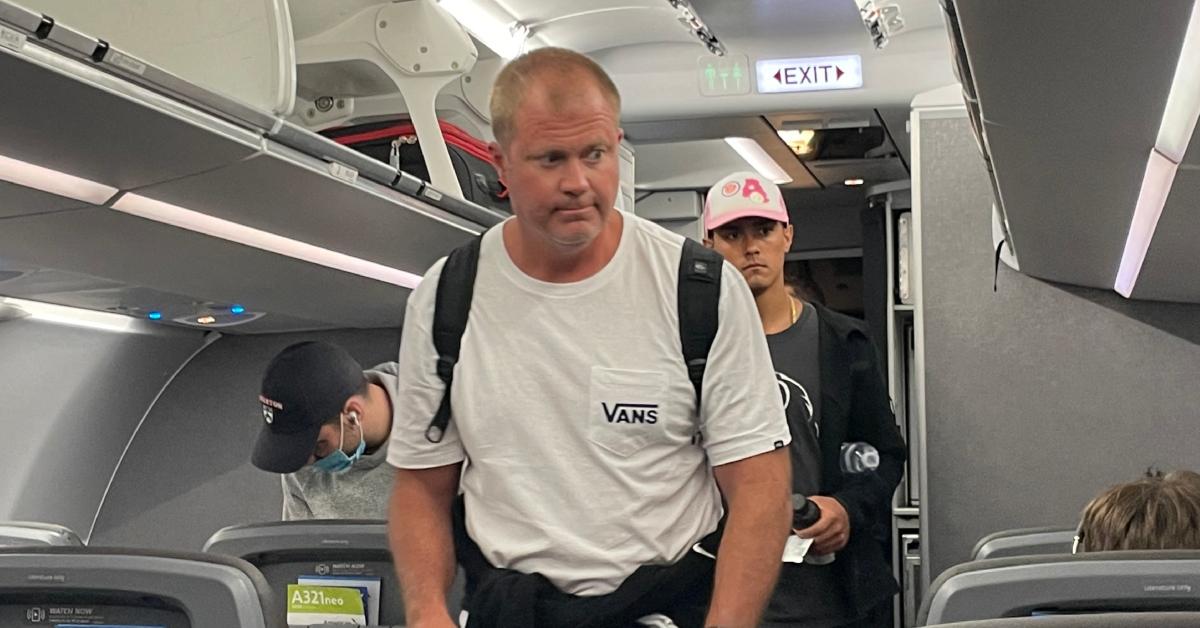 A passenger boarding a plane with a carry-on