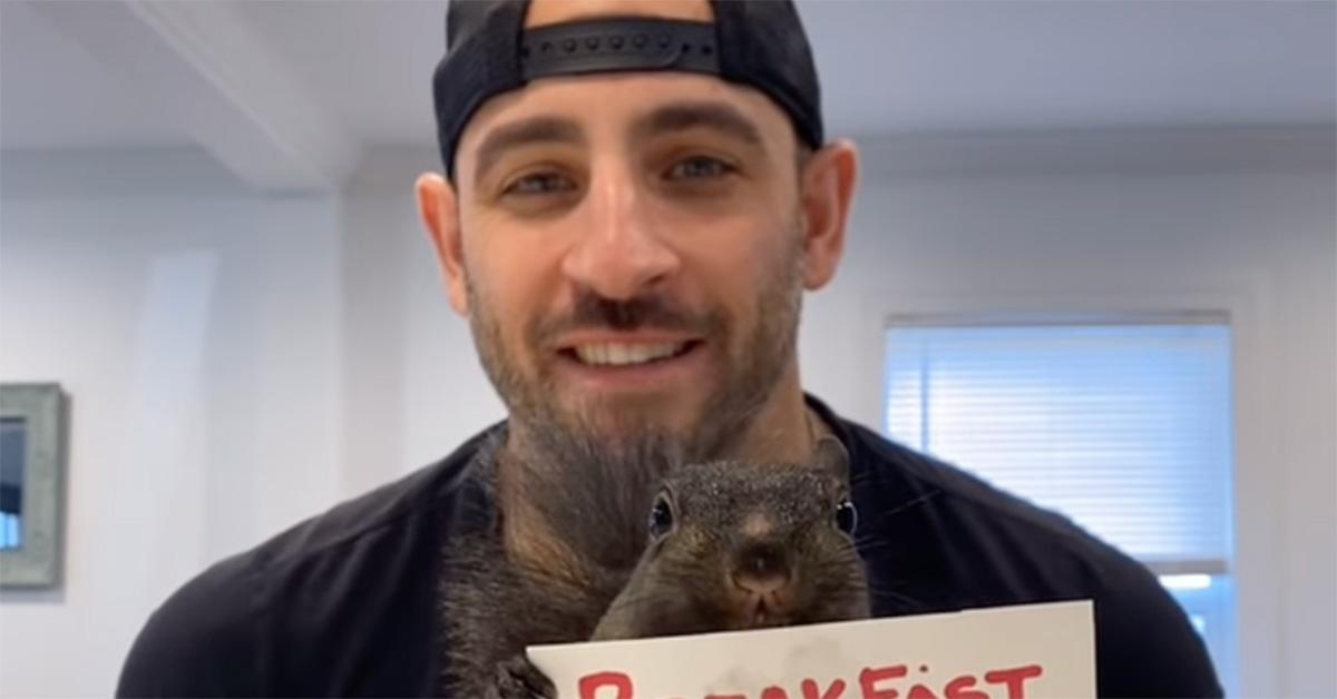 Mark Longo with Peanut the Squirrel at a kitchen counter. 