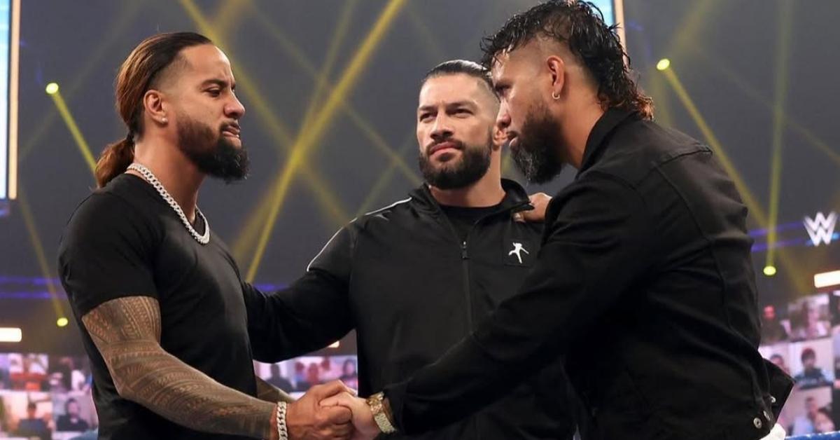 The Uso brothers in the ring with Roman Reigns.