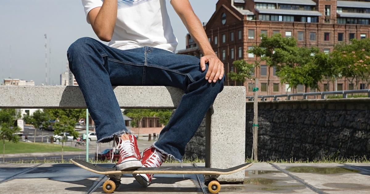 A skateboarder sitting on a public bench