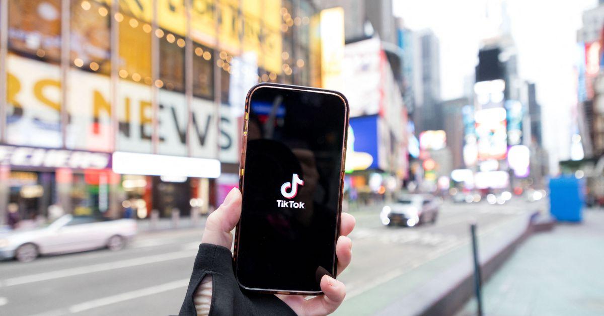 A person holding a phone with the TikTok logo in New York City. 