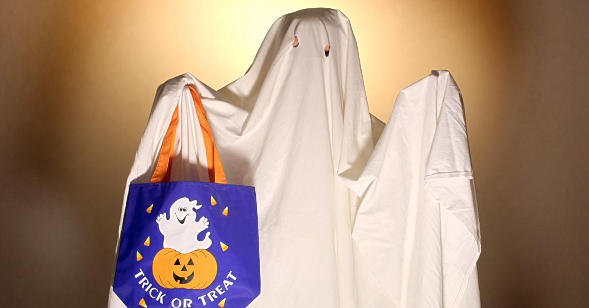 A child wearing a sheet ghost costume.
