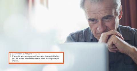 Senior man with hands clasped using laptop