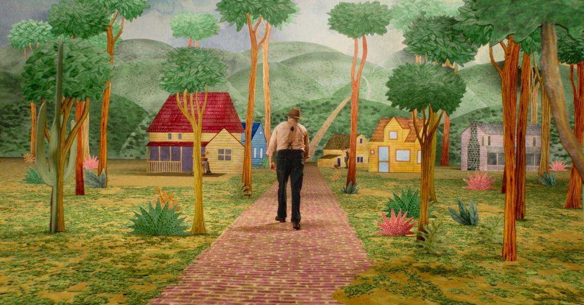 Beau (Joaquin Phoenix) travels through a town of cardboard cutout houses.