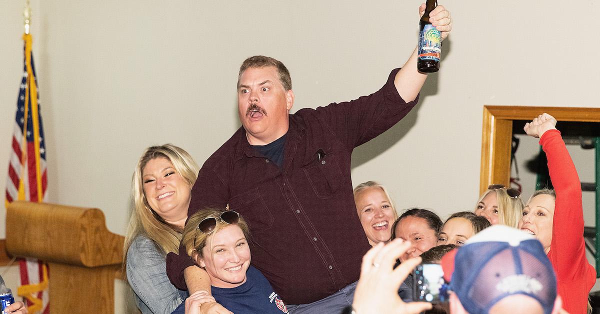 Kevin Heffernan being lifted up while holding a beer