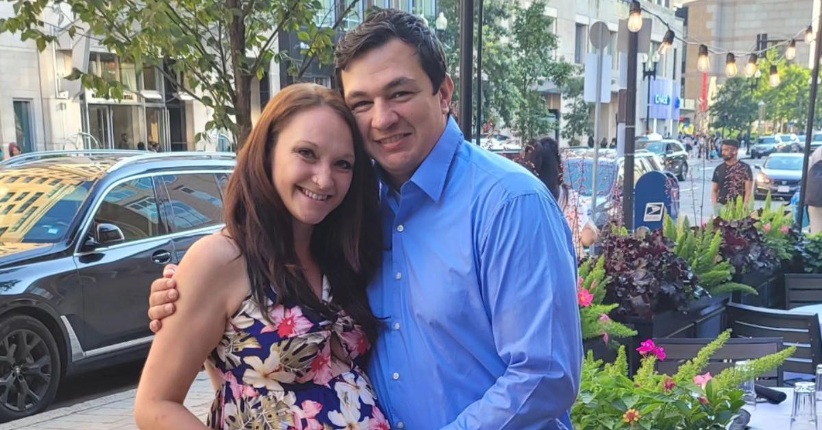 A very pregnant Ashley Sherwood smiles and poses with Shane in front of a restaurant.