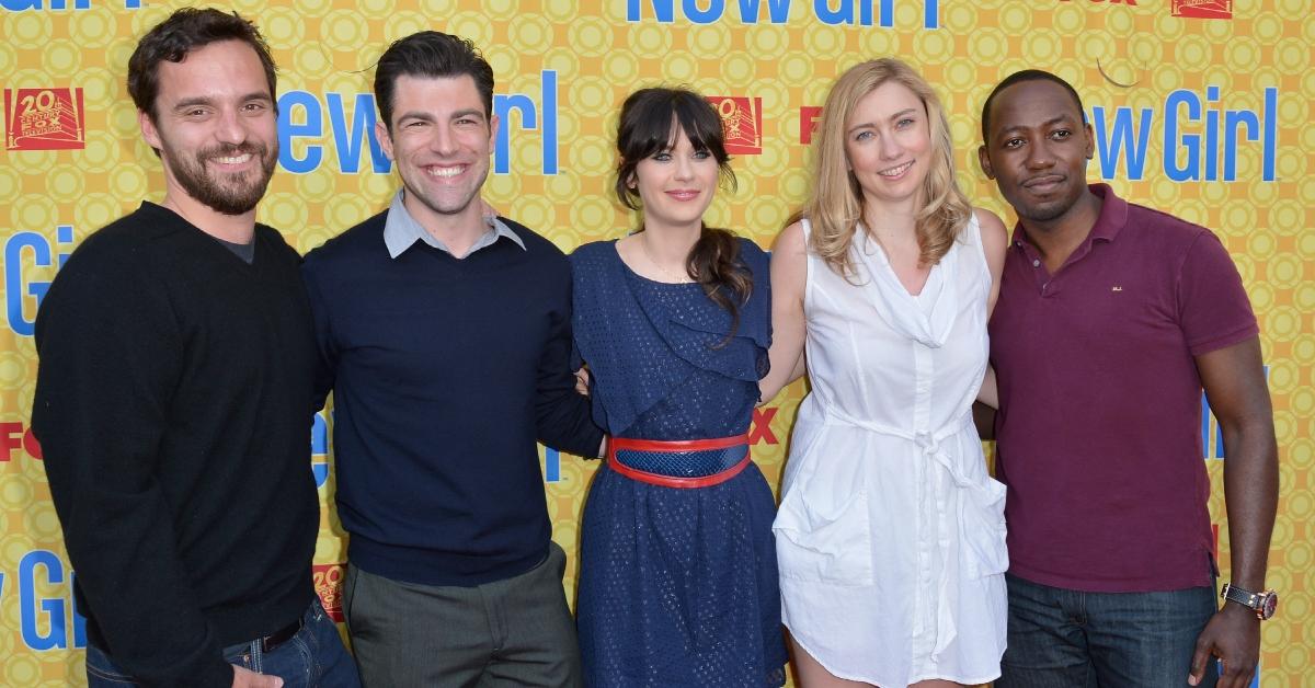 jake johnson, max greenfield, zooey deschanel, executive producer elizabeth meriwether, and lamorne morris posing in front of a new girl background