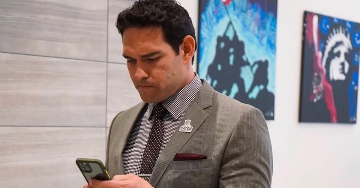 Mark Sanchez reads texts on his phone.