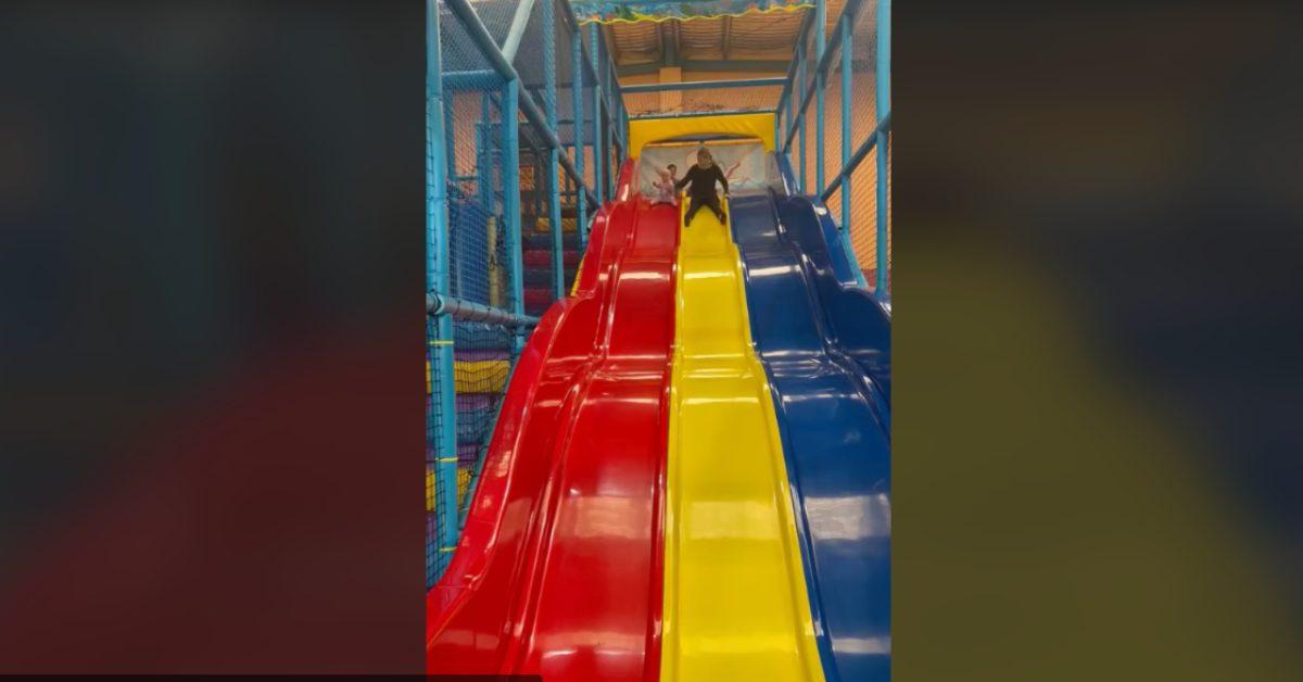 mom slides down giant slide baby