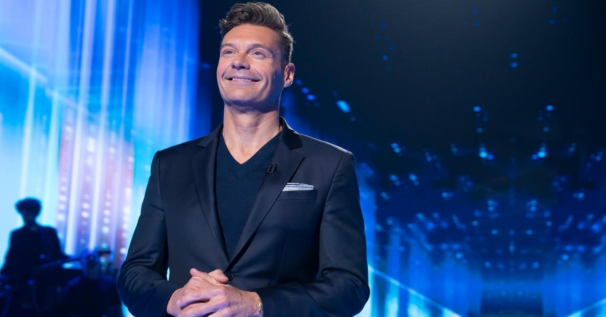 Ryan Seacrest stands on-stage on American Idol