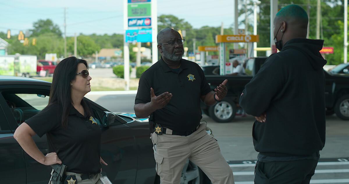 Two officers on Missing: Dead or Alive? ask a witness questions.