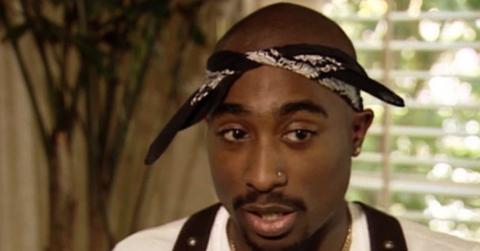 Tupac Shakur wearing a bandana and overalls in an interview.