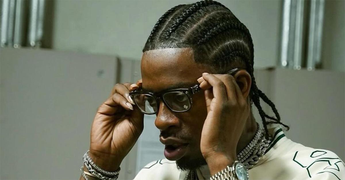 Rich Homie Quan putting glasses on. 