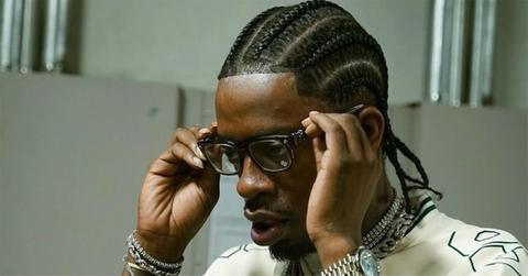 Rich Homie Quan putting glasses on.