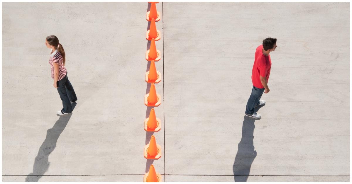 (l-r): A woman and a man on opposite sides of cones.