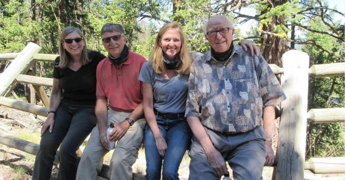 Bill Gates and his siblings and father on a fence. 