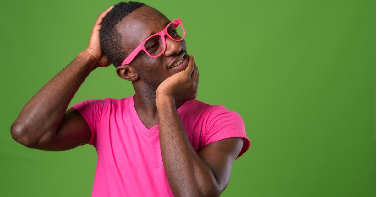 studio shot of young african man wearing pink shirt matched with pink picture id