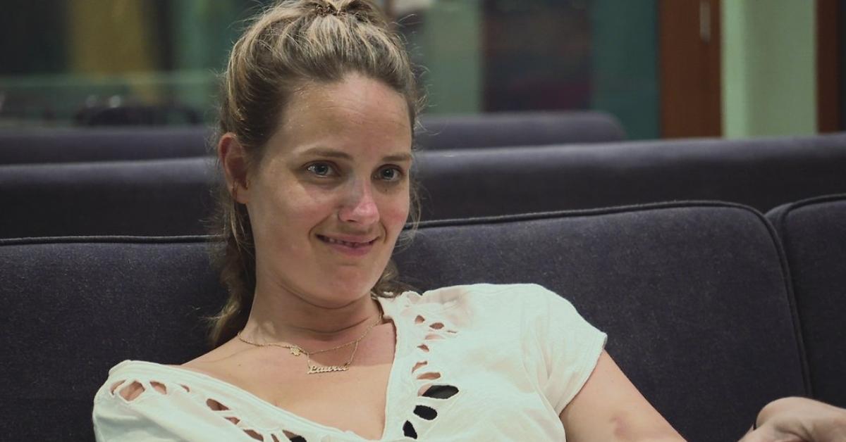 Laurel sits on a couch smiling on The Challenge