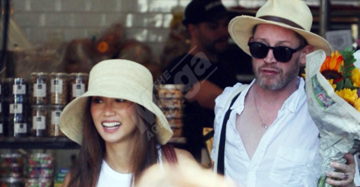 Macaulay Culkin and Brenda Song exit a store wearing hats.