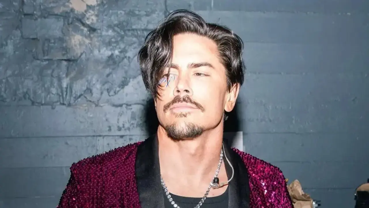 Tom Sandoval in front of a painted brick wall