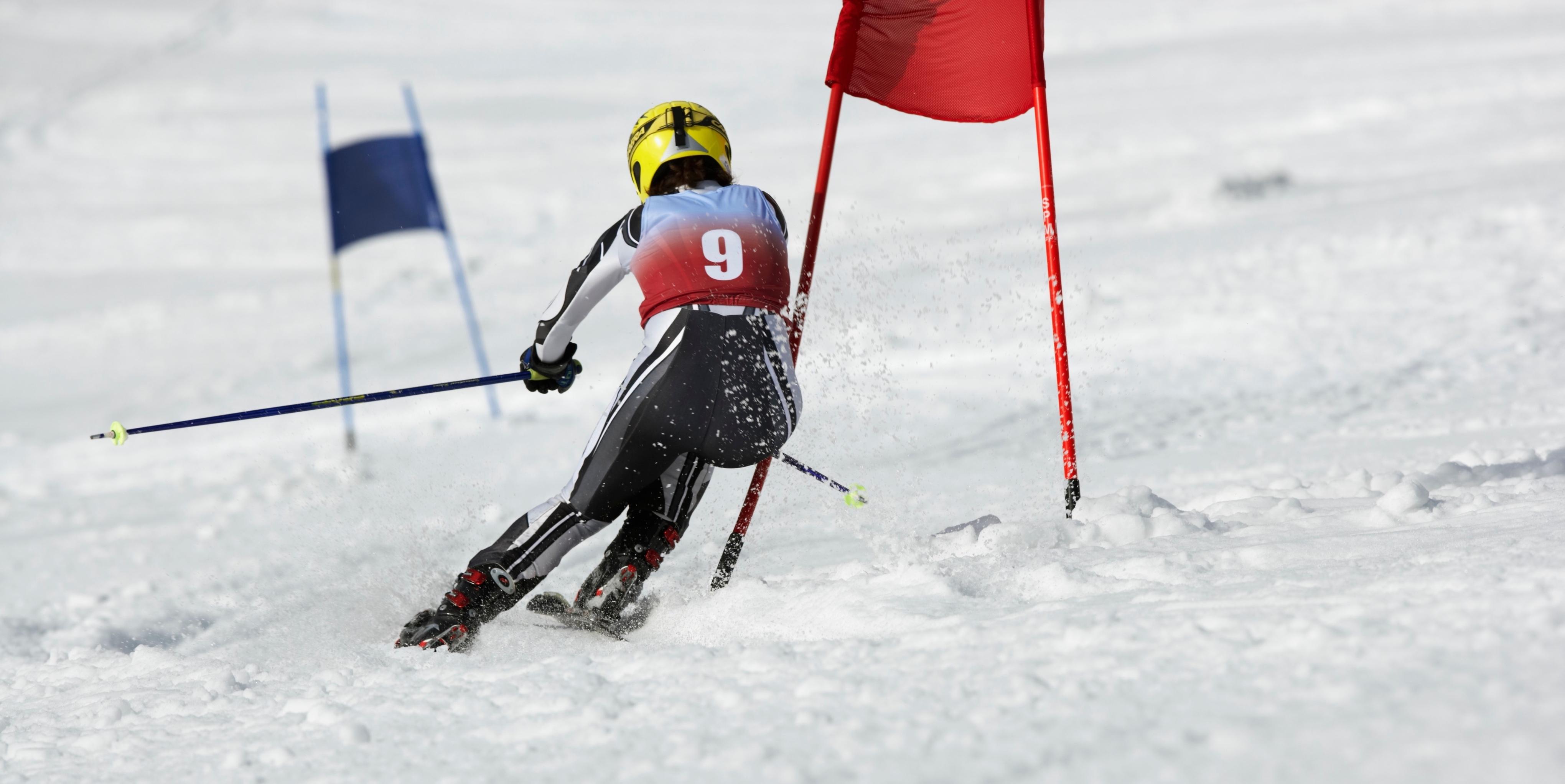 A female skier competing down a slope.