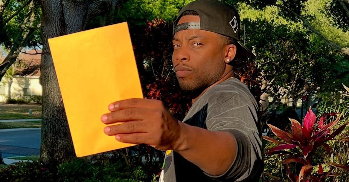 Woody McClain holds up a folder with gender reveal results